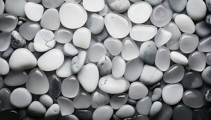Collection of smooth white and gray pebbles arranged in a decorative pattern on a surface