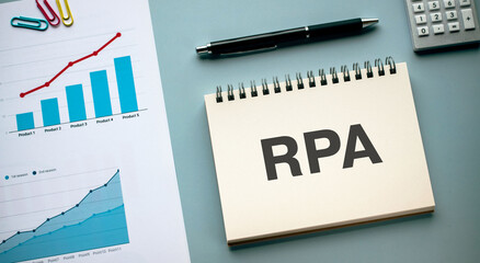 There is notebook with the word RPA. It is an abbreviation for Robotic Process Automation as eye-catching image.