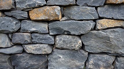 Rough dark gray stone wall texture with modern bright tones and blurred background, offering empty space for captions, symbolizing chaos and contrast between solidity and impermanence.

