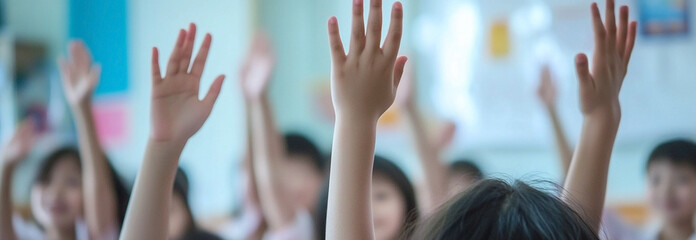 Enthusiastic students raise their hands in a classroom showcasing active participation