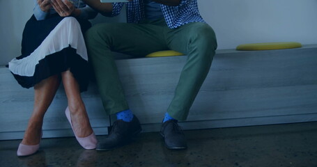 Couple sitting together on bench, holding hands and enjoying conversation indoors
