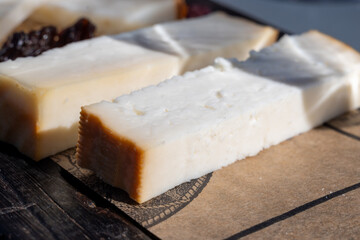 Tasting of Spanish cheeses made on Canary islands, goat cheese, smoked and triangles of manchego curado cheese on wooden plank