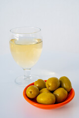 Spanish dry rueda white wine and green olives tapas on white table