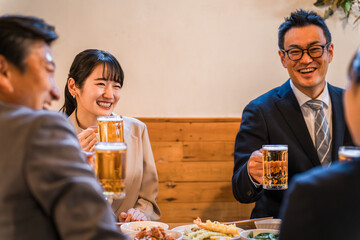 居酒屋・飲み屋で談笑する男女のサラリーマン
