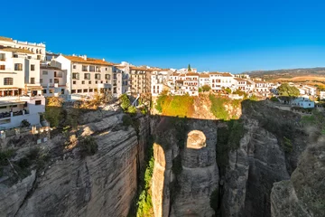 Ingelijste posters Ronda Puente Nuevo The shadow of the Puente Nuevo, the old stone bridge spanning the El Tajo gorge is silhouetted under the whitewashed hill town of Ronda, Spain, in the Malaga province of Southern Spain.   © Kirk Fisher