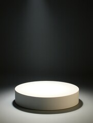 Round white pedestal highlighted in a darkened spotlight background