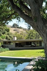 A contemporary home is beautifully positioned amidst a tranquil landscape, featuring a vibrant garden and a shimmering reflective pool bathed in the bright sunlight of the day