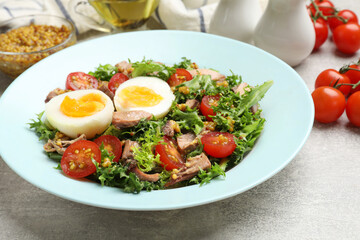 Delicious fresh tuna salad on grey textured table, closeup