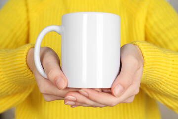 Woman with white ceramic cup, closeup. Mockup for design