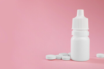 Allergy treatment. Nasal drops and pills on pink background, closeup. Space for text