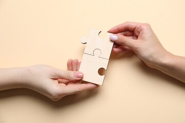 Business strategy and teamwork concept. Partners putting puzzle pieces together on beige...