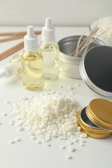 Soy wax and other supplies for making candles on white table