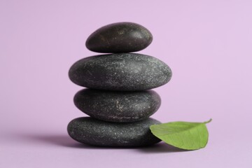 Fototapeta premium Stack of rocks on lilac background. Harmony and life balance