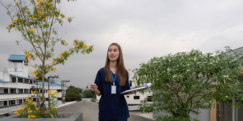 Young female doctor discussing notes outdoors, emphasizing relaxation and communication in...