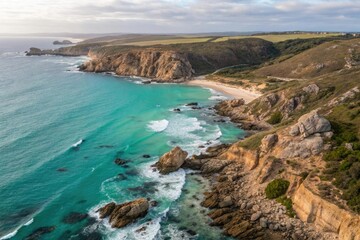 Fototapeta premium Aerial view of a coastline with rocky cliffs and turquoise waves crashing against the shore at low tide, wave, blue, landscape