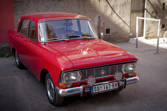 Red Moskvitch 412 (AZLK 412), parked on the street. Fog lights in protective covers. Classic Soviet design with chrome details and a polished finish. 1970s car still in use. 03.10.23. Subotica, Serbia