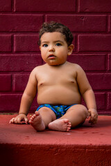 Baby sitting on the sidewalk, all dirty