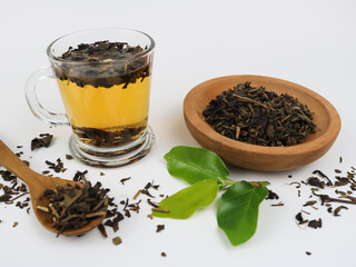 Brewing aromatic tea. Cup with raw tea - on white background