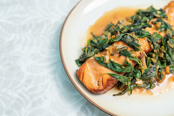 Fried fresh salmon topped with Pad Krapow. Salmon stir-fried with holy basil. Thai fusion food also known as kaprao salmon.