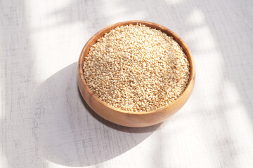 Top view of sesame in wooden bowl on white background. Copy space