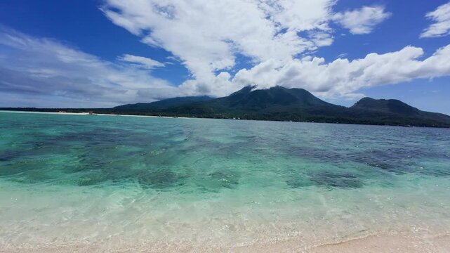 Beeautiful View of Camiguin Island in the Philippines from white Island sand bar. Beautiful Crystal clear tropical waters and volcanic mountains 