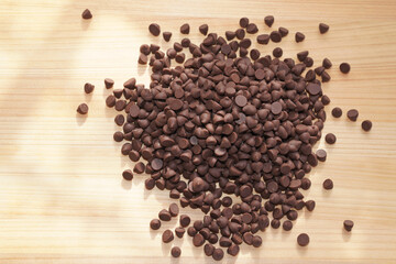 Chocolate chips on wooden board. copy space.