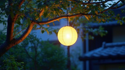 Obraz premium A glowing lantern hanging from a tree branch at dusk.