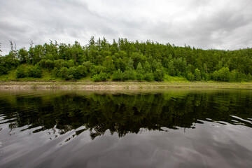 Picturesque lake. Green hills are reflected in the calm water of the Zeya reservoir. Protected Russia.