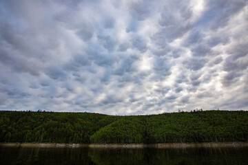 Picturesque lake. Green hills are reflected in the calm water of the Zeya reservoir. Protected Russia.