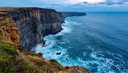 Fototapeta premium Majestic Sea Cliffs Overlooking Turbulent Ocean Waves at Dusk