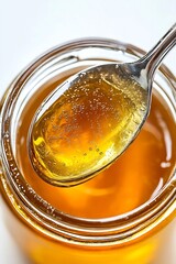 Close-up of honey glistening on a spoon with a rich amber color in a glass jar : Generative AI
