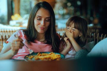 Little Girl Covering Her Mouth Refusing her Mom feeding. Stubborn kid not wanting to eat in a...