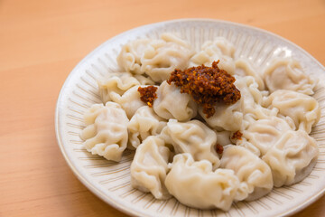 Traditional Chinese Meat Dumpling with Sauce on White Plate