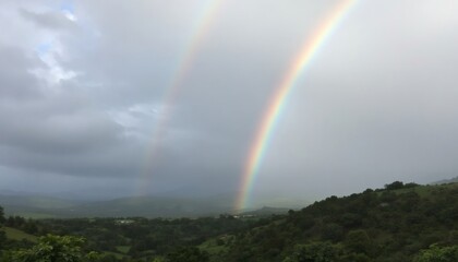 Vibrant Rainbow Spanning Over Serene Green Valley Landscape