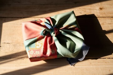 Gift wrapped in Furoshiki fabric on wooden surface