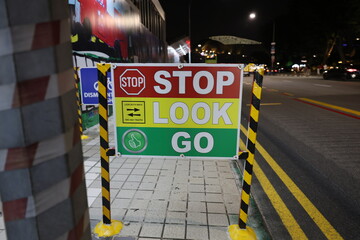 Construction Site Sign: STOP, LOOK, GO (Red, Yellow, Green)Traffic control sign near a construction...