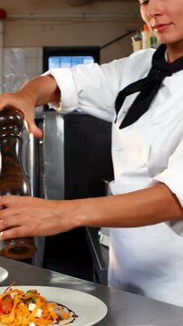 Chef sprinkling pepper on the meal