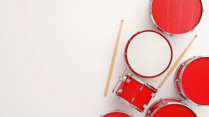 A vibrant arrangement of red drums and wooden drumsticks on a light background, creating a lively musical scene.