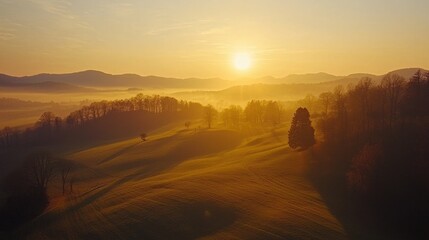 Obraz premium Serene Sunrise Over Rolling Hills and Misty Valley Landscape