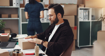 Businessman, box and label with package for logistics, online delivery or distribution at storage warehouse. Man, distributor or employee packing cargo for supply chain, ecommerce or freight service