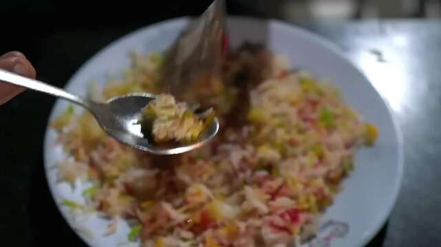 Playing with Colorful Zarda Sweet Rice Dessert with Spoon and Fork on a White Plate
