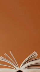 Open Book with Pages Fanned Out Against Minimalist Brown Background