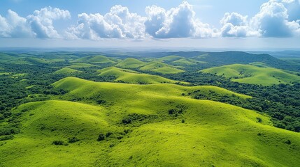 Lush green hills under a bright blue sky with fluffy clouds, showcasing a serene landscape