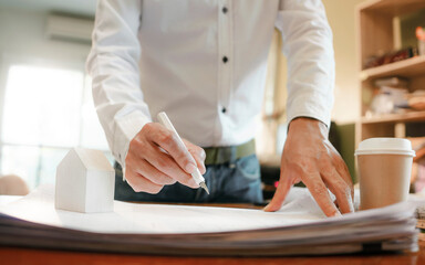 architect working in his studio. with fountain pen and blueprint of the new apartment for build architectural construction house building. architect studio.