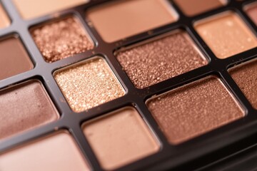 Fototapeta premium Close-up of a makeup eyeshadow palette featuring shimmering and matte shades in warm neutral tones. Ideal for beauty, cosmetics, and fashion concepts. Ai generative