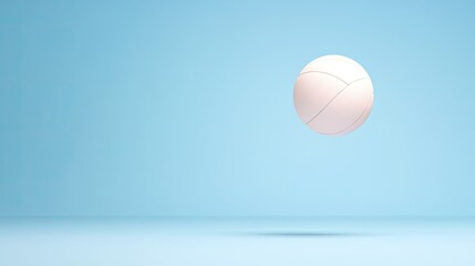 A volleyball suspended in mid-air against a soft blue background, creating a serene atmosphere