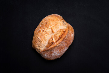 Homemade whole grain freshly baked bread. Black background, top view