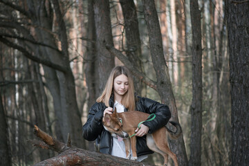 Young beautiful girl in the forest with a dog.