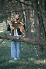 Young beautiful girl in the forest with a dog.