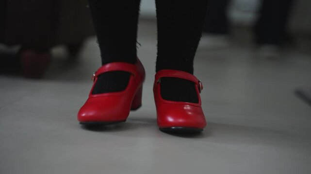 Close-up of two cute little red flamenco shoes a little girl wore. Dance competition.